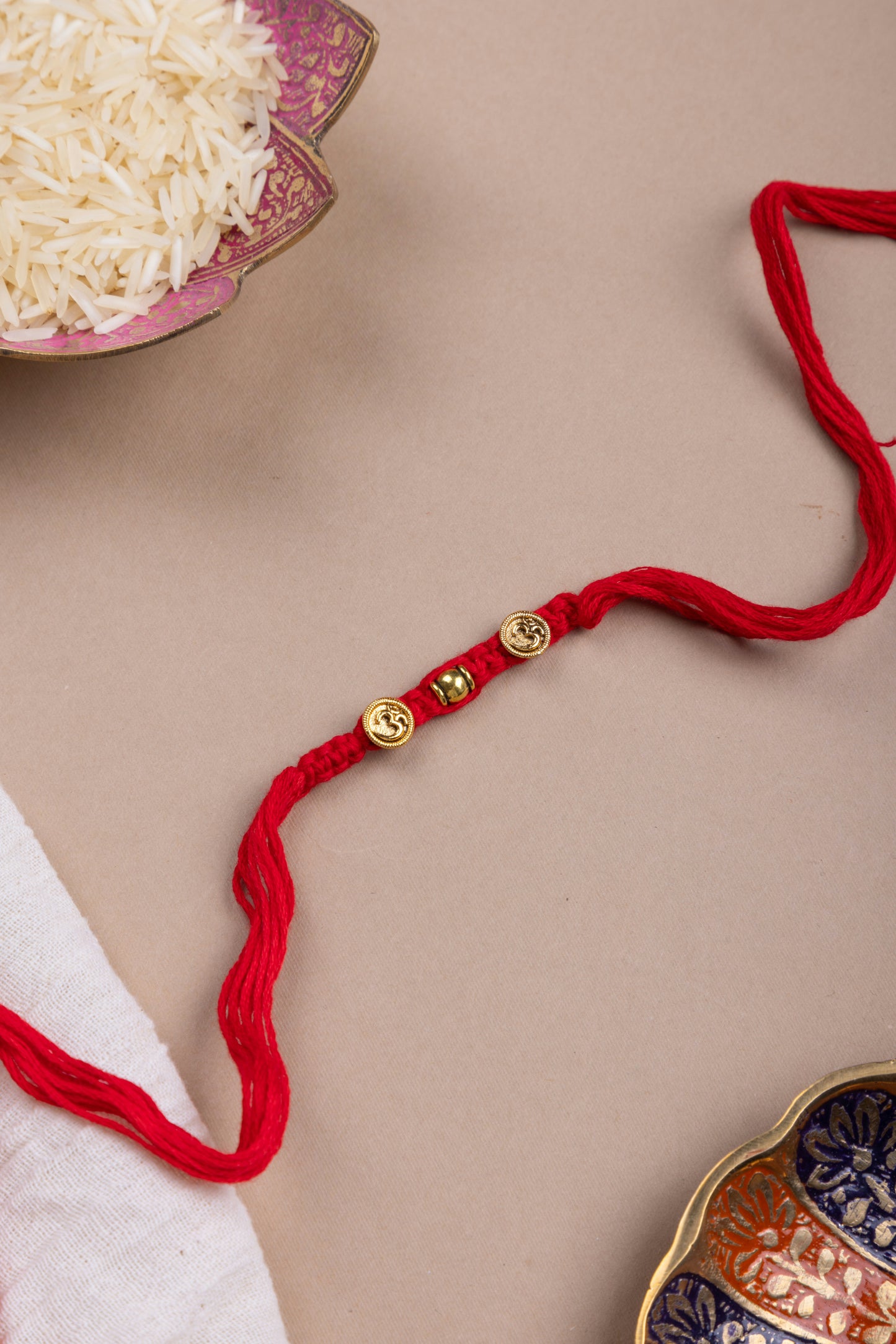 Golden om coin Red thread weave rakhi